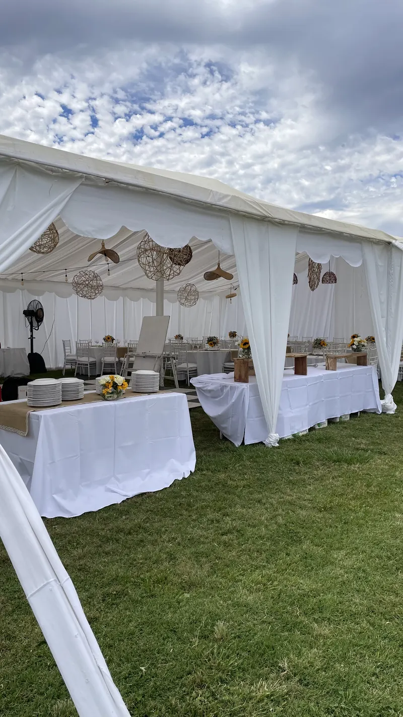 Interior de un toldo con mesas decoradas para una celebración